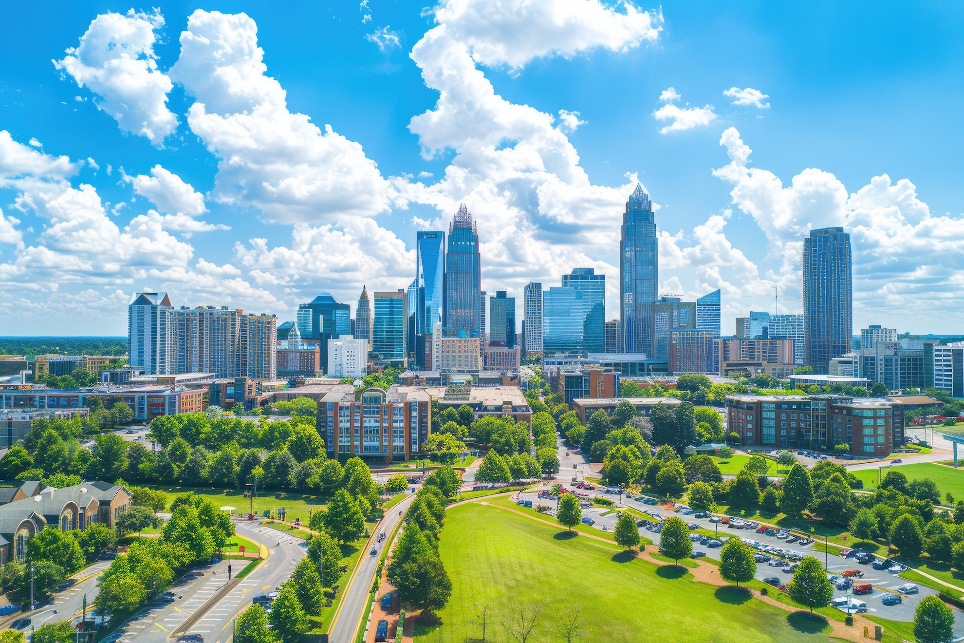 Aerial view of Charlotte, North Carolina financial district skyline with green parks and blue sky